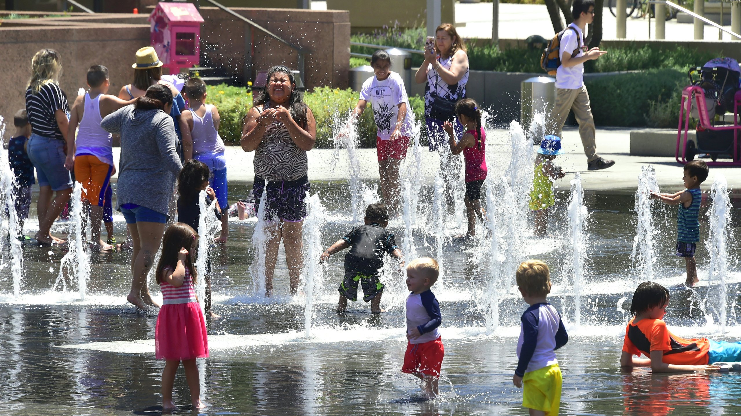 Children and adults cool off at the Grand Park splash pad in downtown Los Angeles, California on June 19, 2017, amid a Southern California heatwave with highs again forecast to hit triple-digits in some Los Anegels County communities. (Frederic J. Brown/AFP via Getty Images)