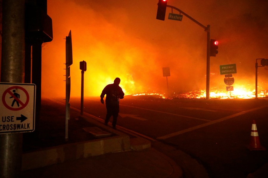 In this Oct. 11, 2019, photo, a bystander watches the Saddleridge Fire in Sylmar, Calif. (AP Photo/David Swanson)