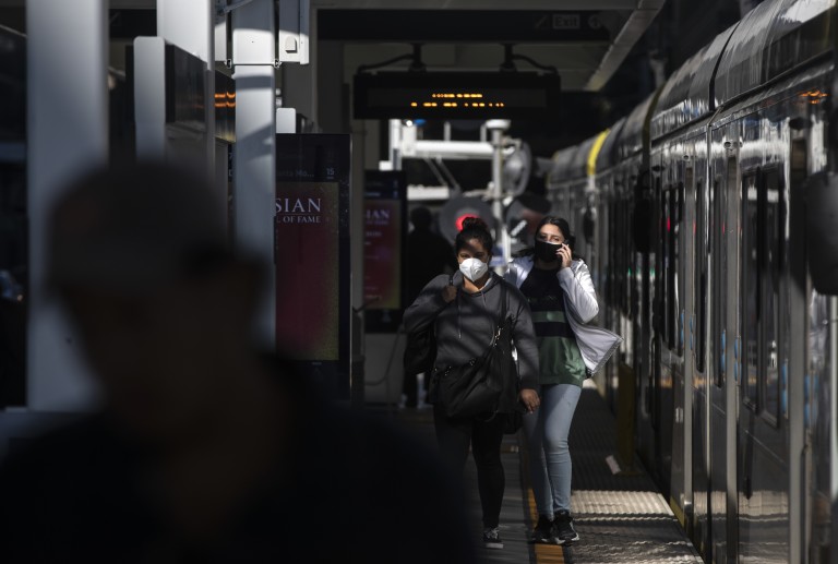 Metro Blue Line riders exit a train at Pico station on March 26, 2020. (Brian van der Brug / Los Angeles Times)