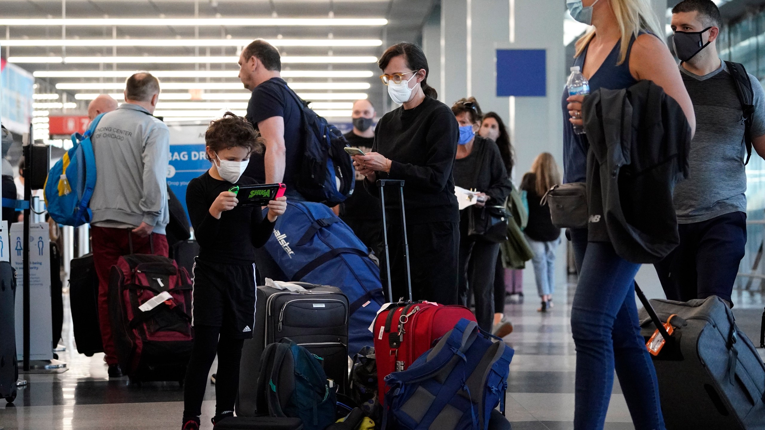 Travelers are lining up at O'Hare airport in Chicago, Friday, July 2, 2021. (AP Photo/Nam Y. Huh)