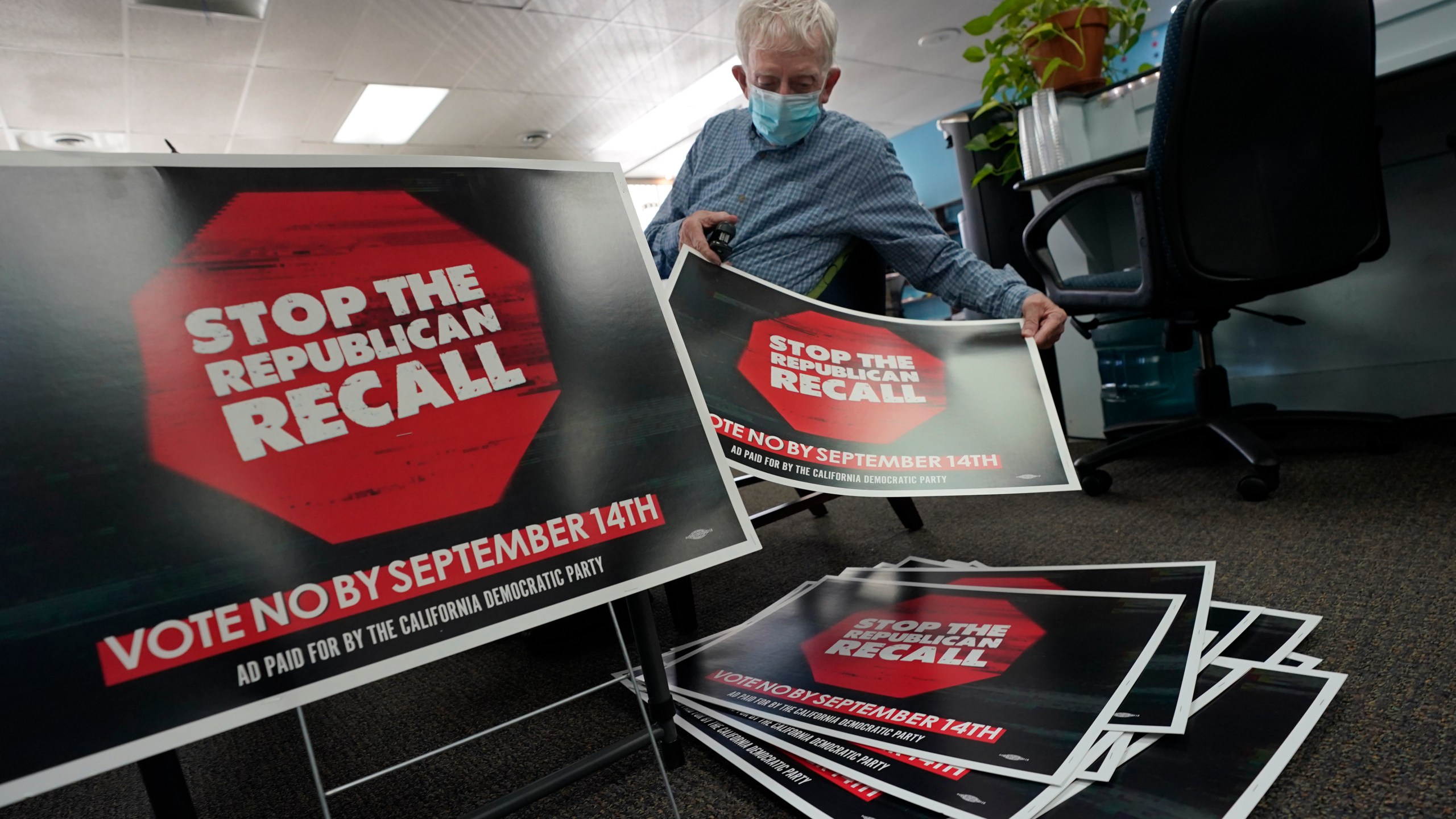 Volunteer Merle Canfield assembles yard signs against the Sept. 14, recall election of Gov. Gavin Newsom, at the Fresno County Democratic Party headquarters in Fresno, Calif., Thursday July 29, 2021. While Democratic registration almost doubles that of Republicans in the state, Democratic Party leaders fear Republicans appear more eager to vote. (AP Photo/Rich Pedroncelli))