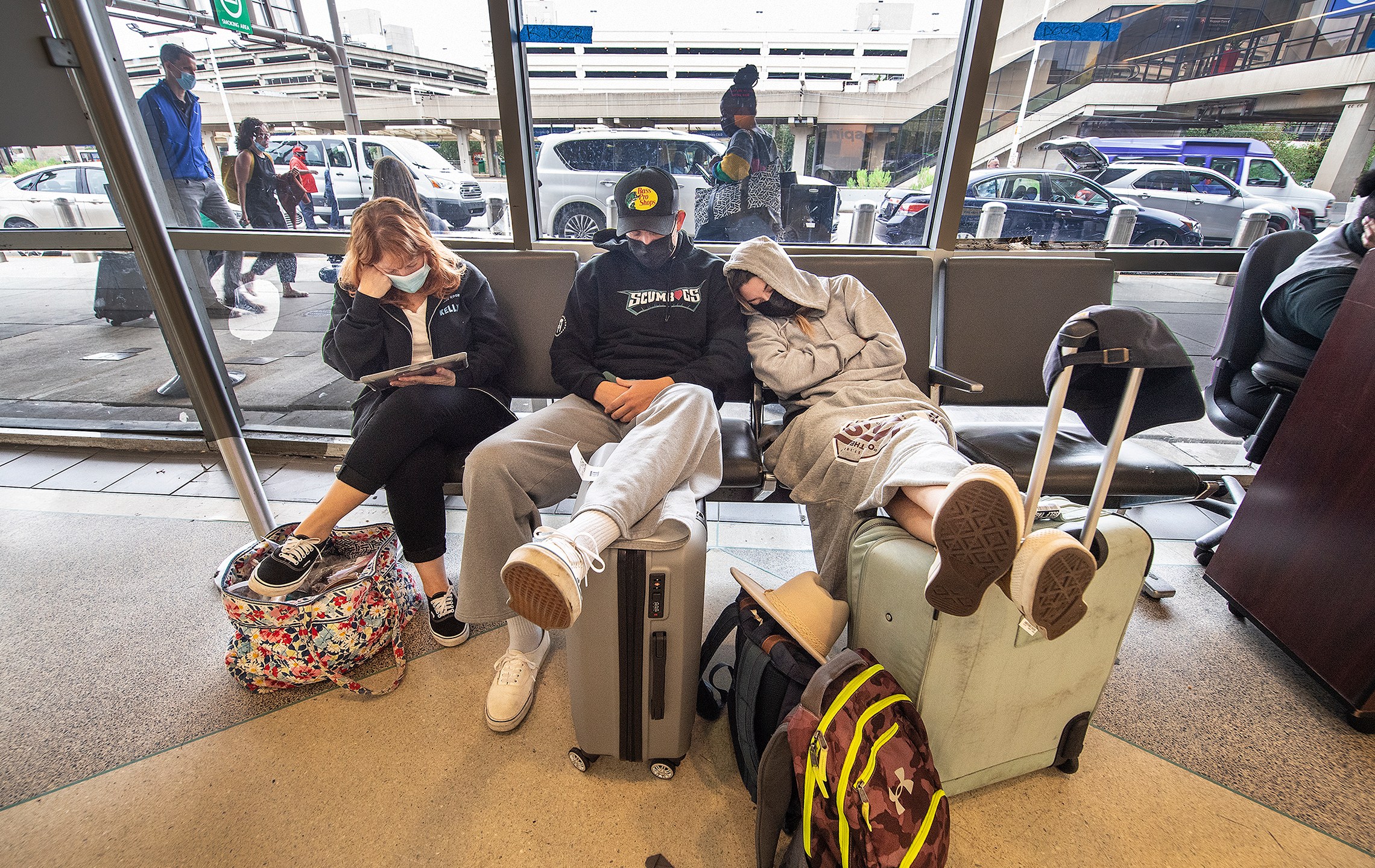 Stranded travelers sleep on the seats of the ticketing waiting area, Tuesday, Aug. 3, 2021. at Philadelphia International Airport in Philadelphia. Their schedule flight to Los Angels was delayed until Thursday, after Spirit canceled nearly half its schedule for Tuesday, the third straight day of extremely high cancellation numbers at the budget airline. (Jose F. Moreno/The Philadelphia Inquirer via AP)