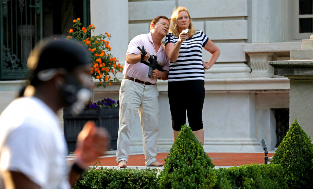 In this June 28, 2020 file photo, armed homeowners Mark and Patricia McCloskey, standing in front their house confront protesters marching to St. Louis Mayor Lyda Krewson's house in the Central West End of St. Louis. (Laurie Skrivan/St. Louis Post-Dispatch via AP, File)