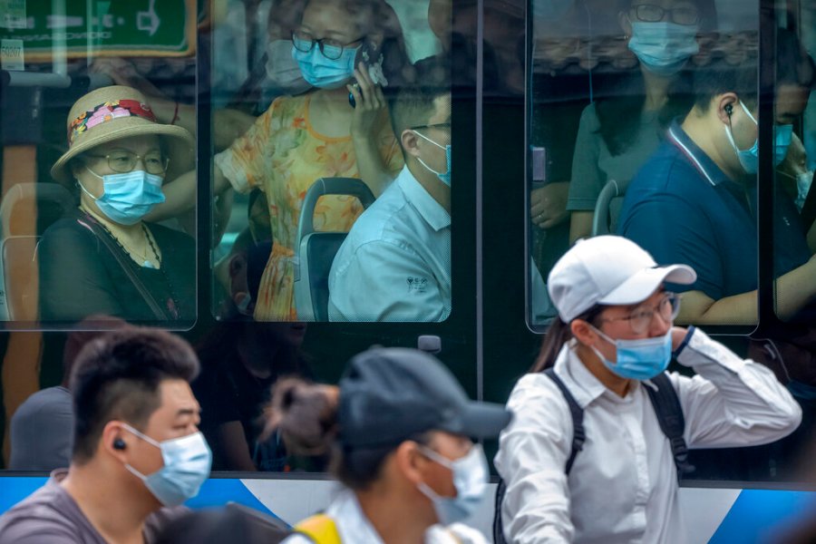 People wearing face masks to protect against COVID-19 ride on a bus during the morning rush hour in Beijing, Wednesday, Aug. 4, 2021. (AP Photo/Mark Schiefelbein)