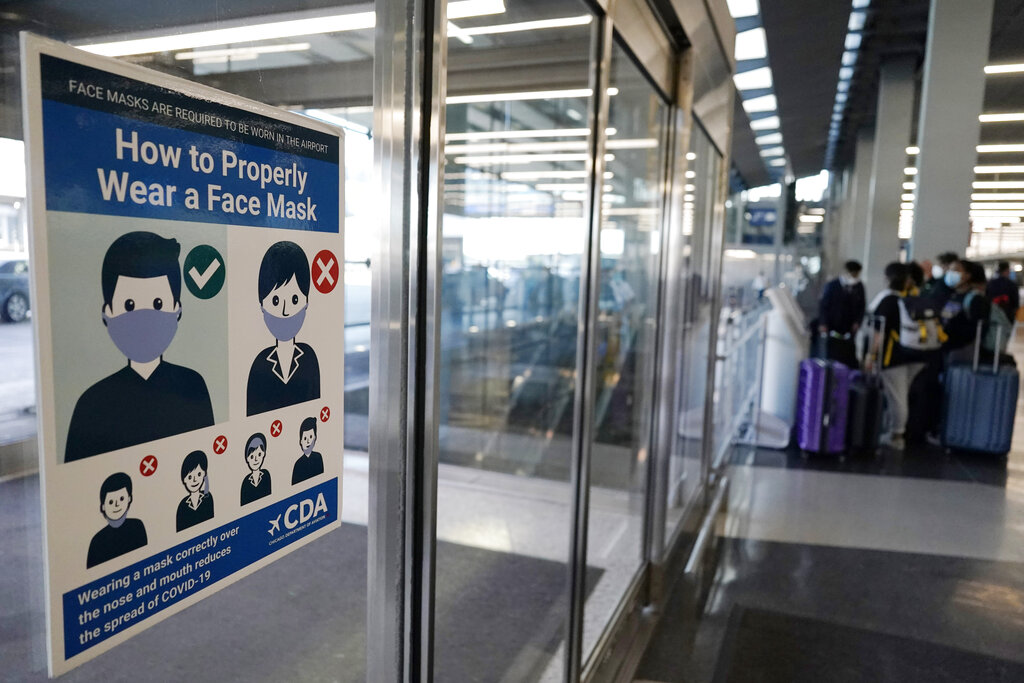 This July 2, 2021 photo shows a sign stating face coverings are required is displayed at O'Hare airport in Chicago. (AP Photo/Nam Y. Huh)