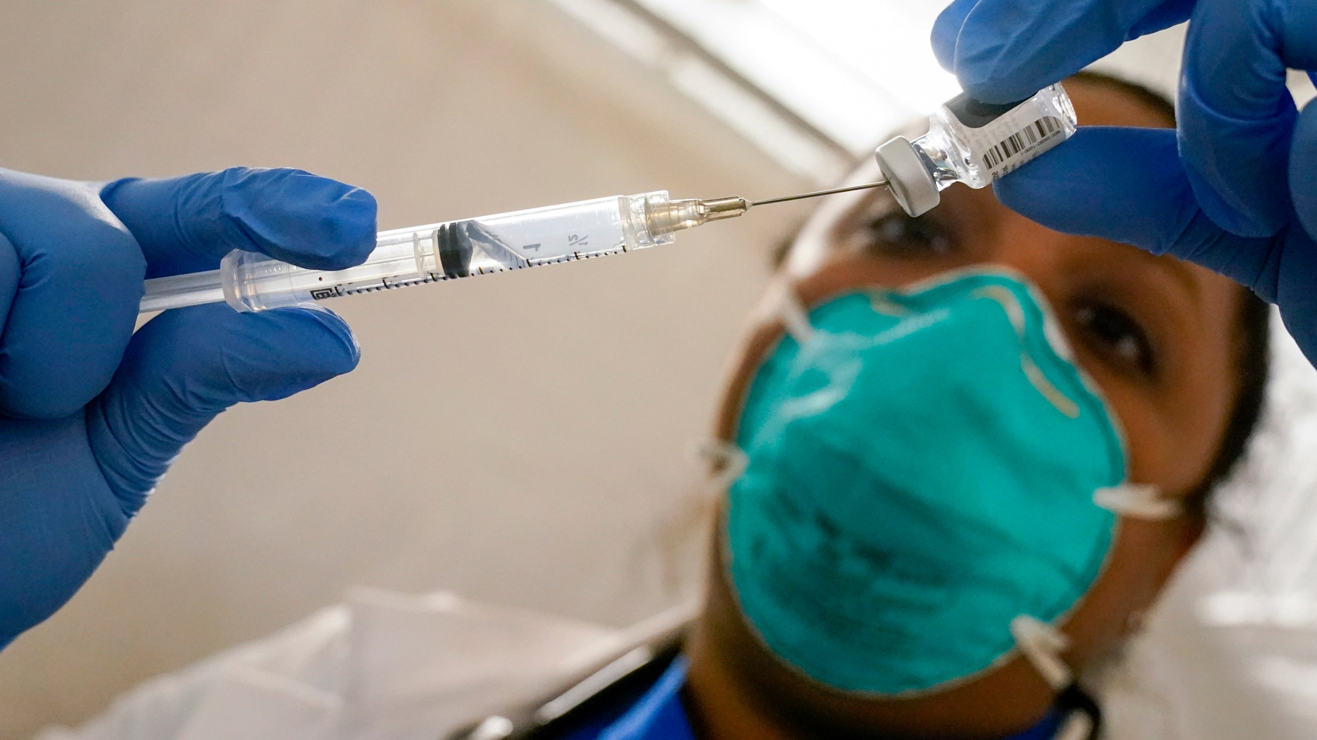 In this Jan. 15, 2021, file photo, Dr. Yomaris Pena, Internal Medicine Physician with Somos Community Care at a COVID-19 extracts the last bit of Pfizer-BioNTech COVID-19 Vaccine out of a vial so as not to waste it at a vaccination site at the Corsi Houses in the East Harlem neighborhood of New York. (AP Photo/Mary Altaffer, File)