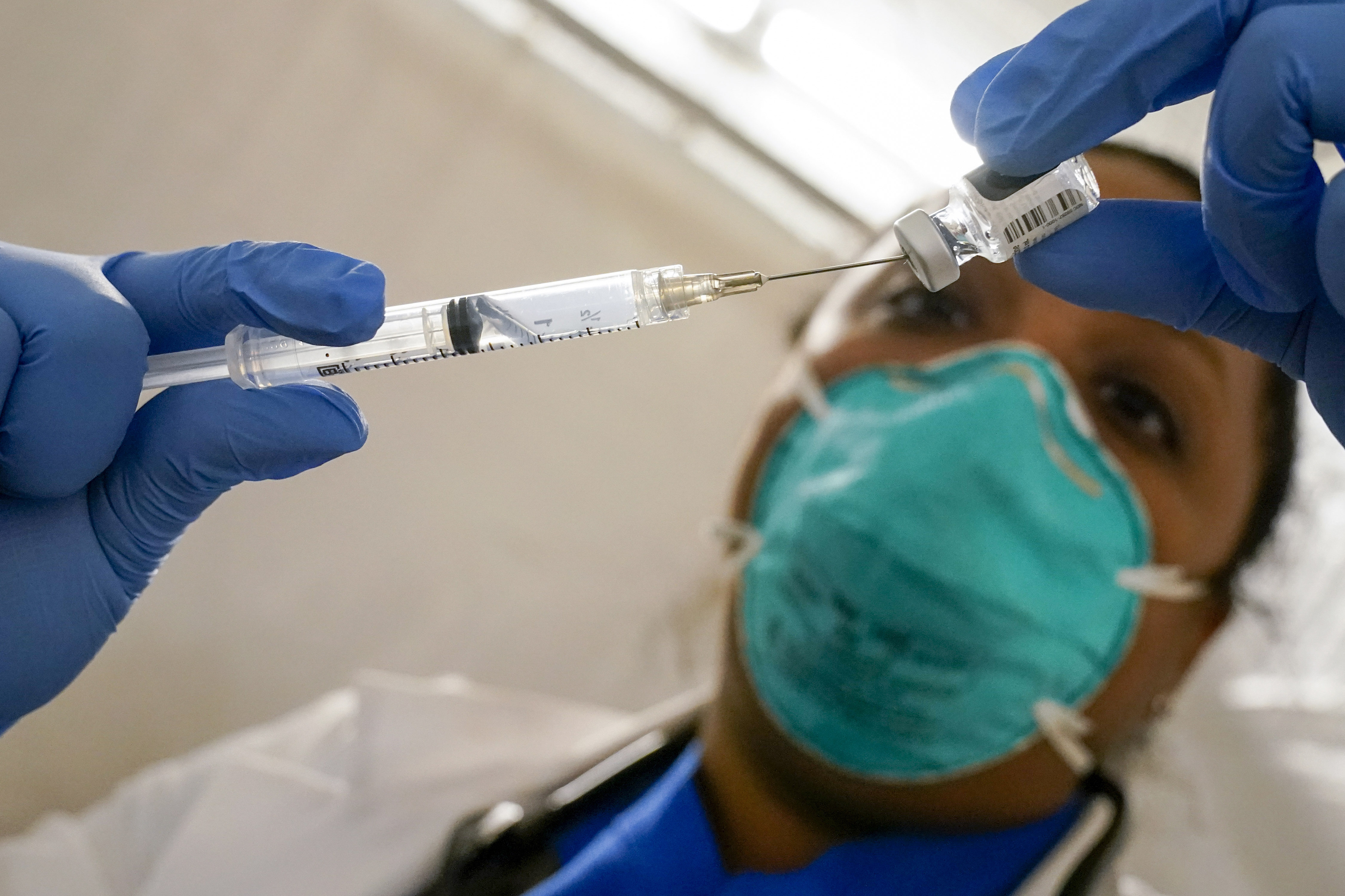 In this Jan. 15, 2021, file photo, Dr. Yomaris Pena, Internal Medicine Physician with Somos Community Care at a COVID-19 extracts the last bit of Pfizer-BioNTech COVID-19 Vaccine out of a vial so as not to waste it at a vaccination site at the Corsi Houses in the East Harlem neighborhood of New York. (AP Photo/Mary Altaffer, File)