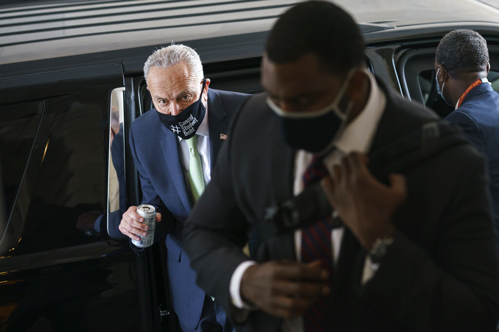 Senate Majority Leader Chuck Schumer, D-N.Y., arrives with his security detail as senators convene for a rare weekend session to continue work on the $1 trillion bipartisan infrastructure bill, at the Capitol in Washington, Sunday, Aug. 8, 2021. (AP Photo/J. Scott Applewhite)