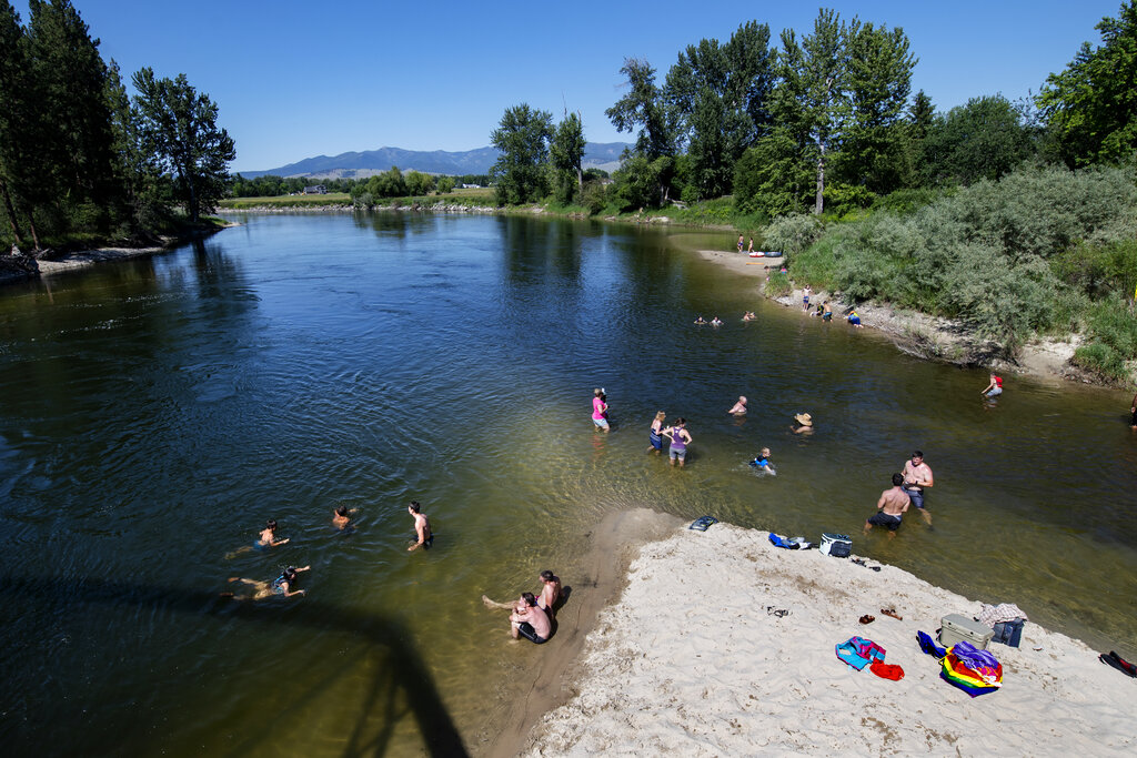 In this June 30, 2021 file photo Missoulians cool off in the Bitterroot River as temperatures crested 100 degrees Fahrenheit in Missoula, Mont. (AP Photo/Tommy Martino, File)