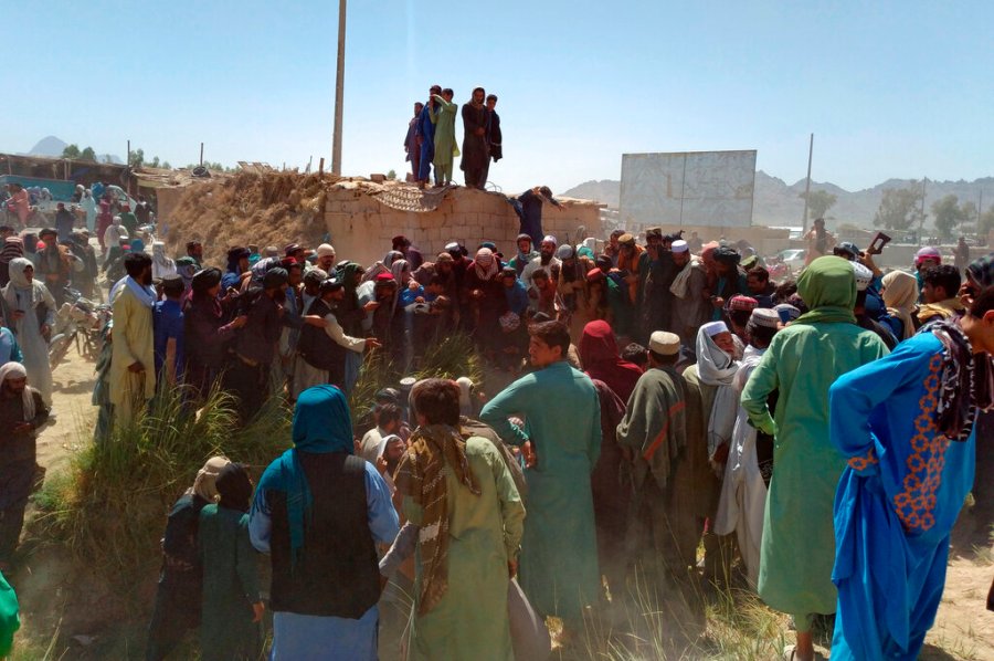 Taliban fighters and Afghans gather around the body of a member of the security forces who was killed, inside the city of Farah, capital of Farah province, southwest Afghanistan, Wednesday, Aug. 11, 2021. (AP Photo/Mohammad Asif Khan)