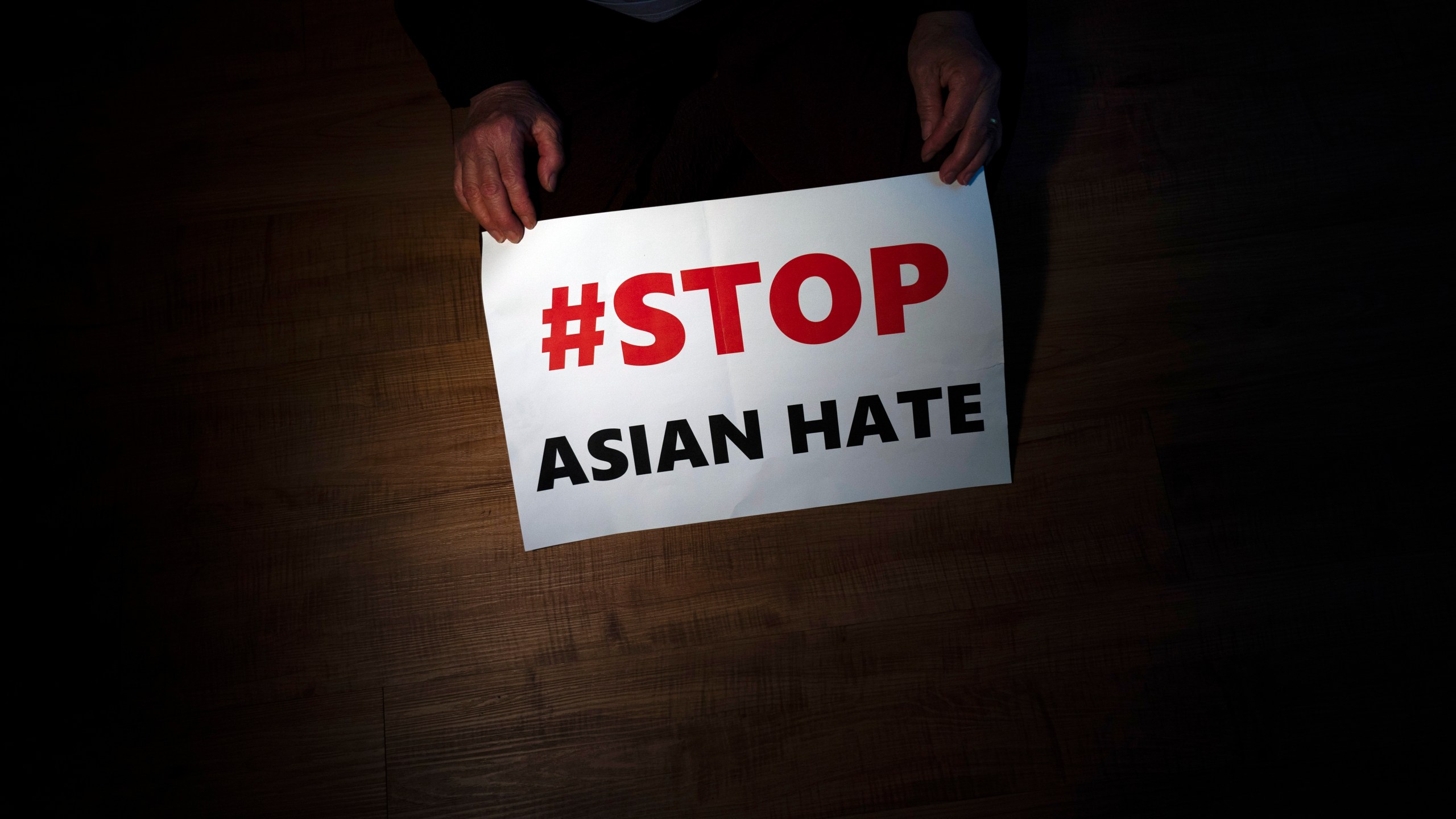 In this March 31, 2021, file photo, Jen Ho Lee, a 76-year-old South Korean immigrant, poses in her apartment in Los Angeles with a sign from a recent rally against anti-Asian hate crimes she attended.(AP Photo/Jae C. Hong, File)