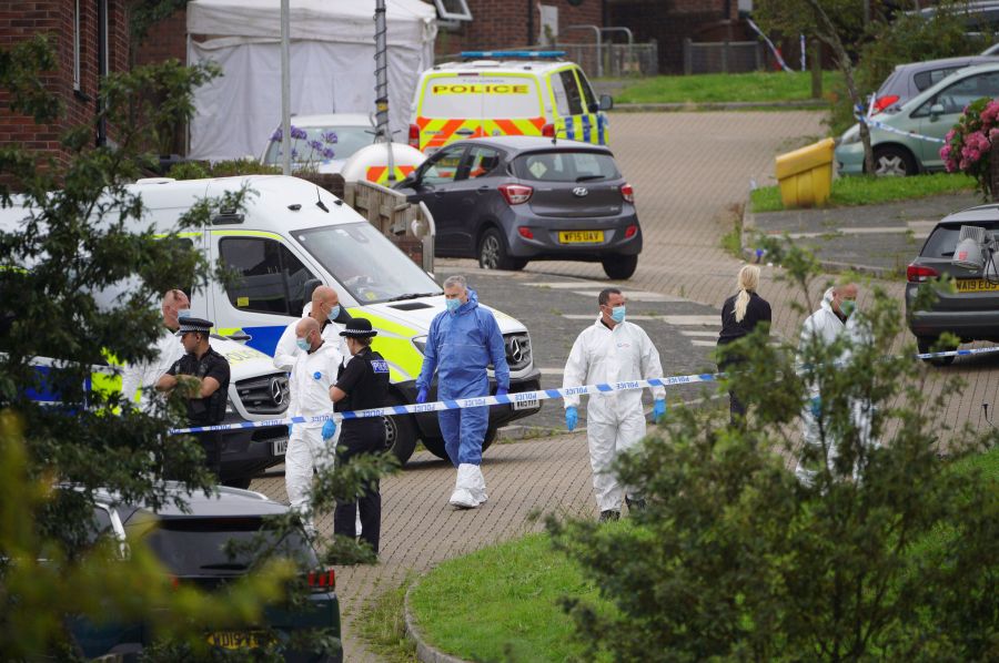 Forensic officers walk in Biddick Drive in the Keyham area of Plymouth, England Friday Aug. 13, 2021 where six people were killed in a shooting incident. (Ben Birchall/PA via AP)