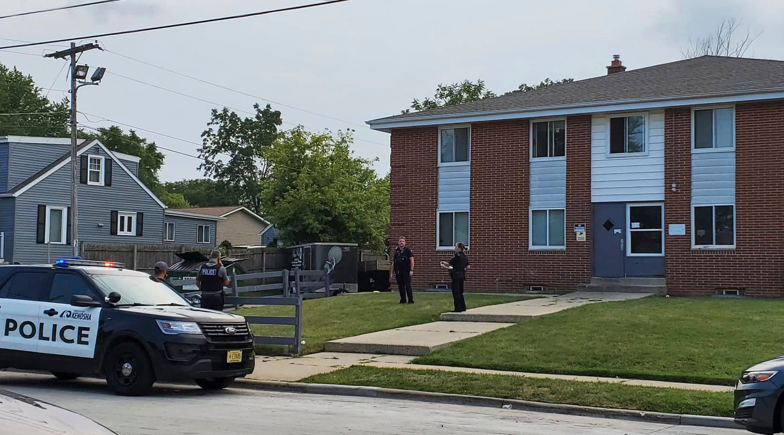 Kenosha police investigate a shooting at 40th Avenue and 45th Street on the city's north side Tuesday, Aug. 10, 2021, in Kenosha, Wis. A 19-year-old woman was using a handgun's laser sight as a cat toy when she accidentally shot a friend, according to prosecutors. The 19-year-old woman was charged Thursday with injury by negligent use of a weapon. (Terry Flores/The Kenosha News via AP)