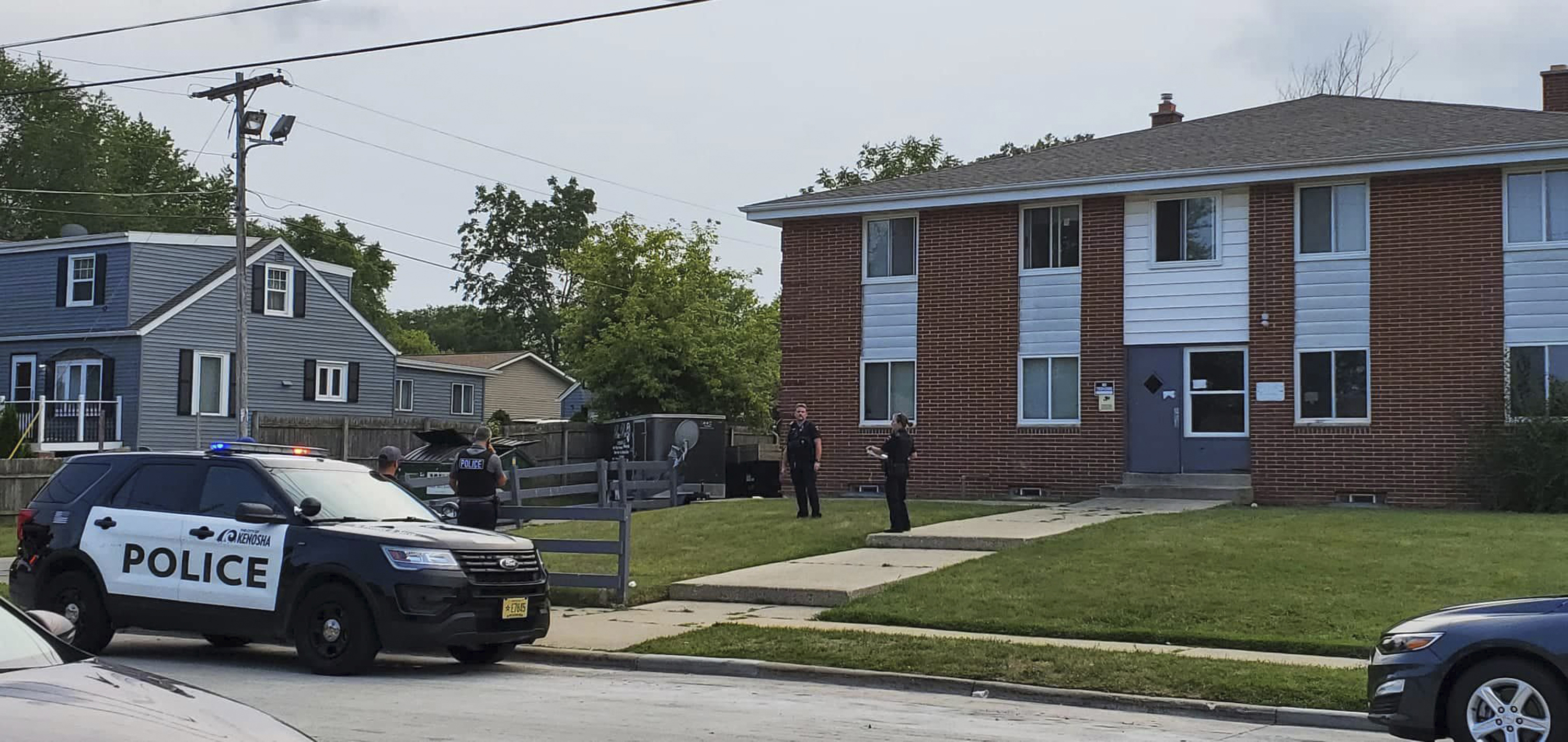 Kenosha police investigate a shooting at 40th Avenue and 45th Street on the city's north side Tuesday, Aug. 10, 2021, in Kenosha, Wis. A 19-year-old woman was using a handgun's laser sight as a cat toy when she accidentally shot a friend, according to prosecutors. The 19-year-old woman was charged Thursday with injury by negligent use of a weapon. (Terry Flores/The Kenosha News via AP)