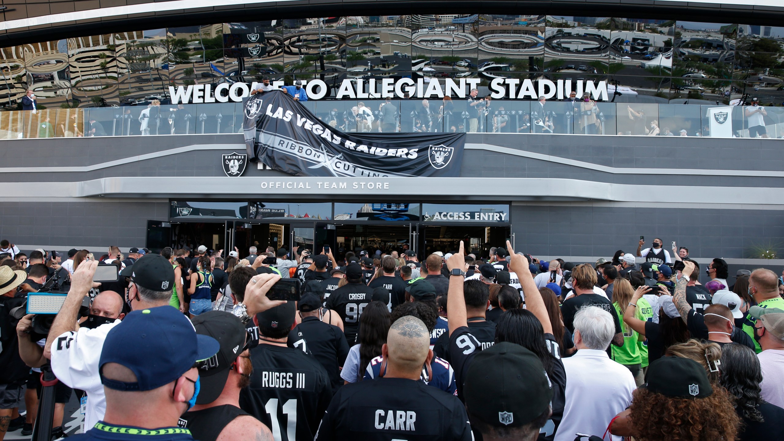 Fans enter Allegiant Stadium before an NFL preseason football game between the Las Vegas Raiders and the Seattle Seahawks, Saturday, Aug. 14, 2021, in Las Vegas. (AP Photo/Steve Marcus)