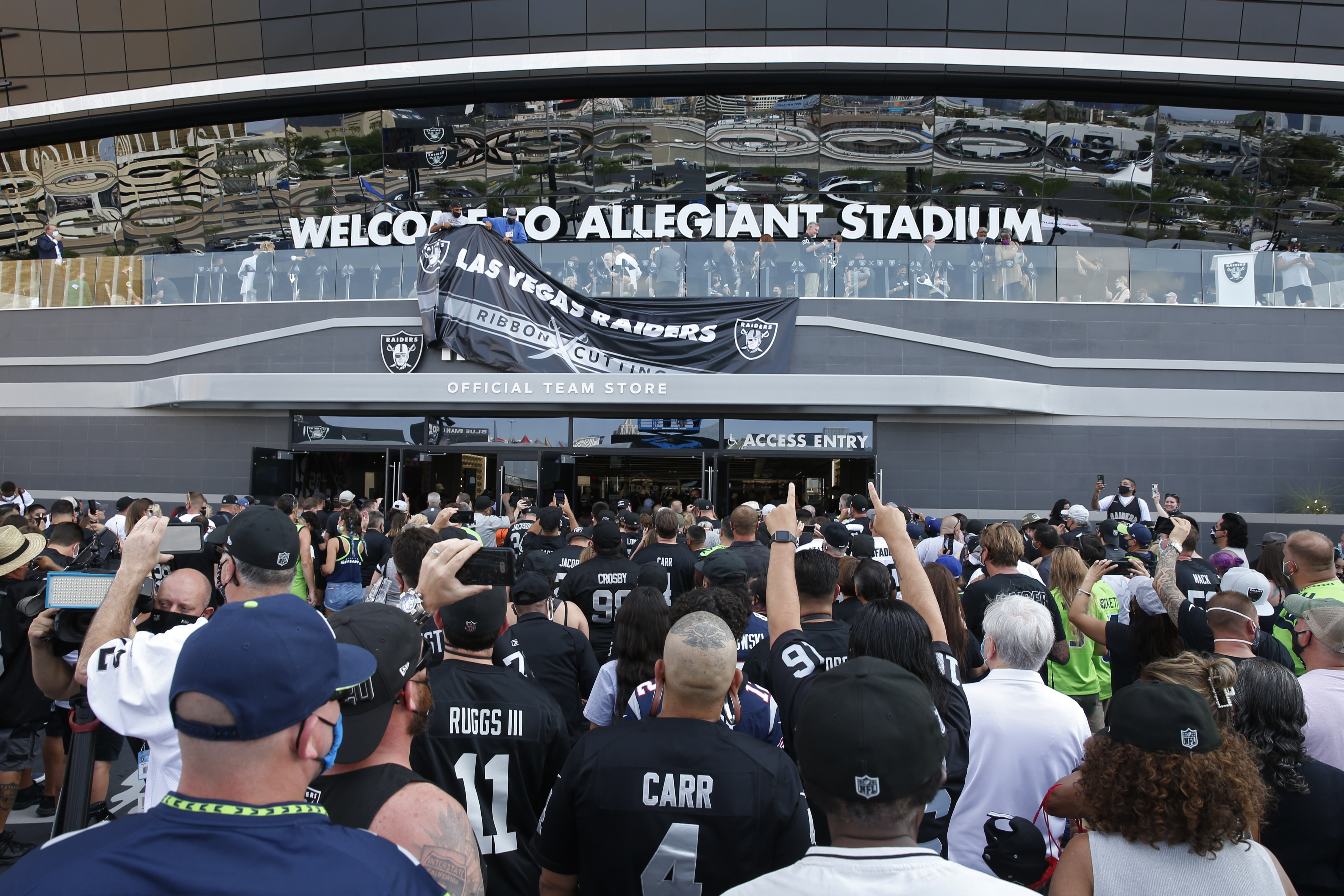 Fans enter Allegiant Stadium before an NFL preseason football game between the Las Vegas Raiders and the Seattle Seahawks, Saturday, Aug. 14, 2021, in Las Vegas. (AP Photo/Steve Marcus)