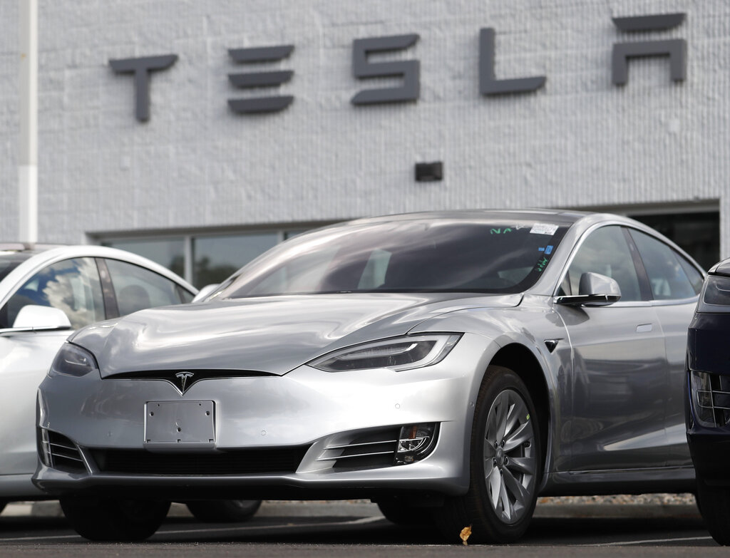 This July 8, 2018, file photo shows Tesla 2018 Model 3 sedans sitting on display outside a Tesla showroom in Littleton, Colo. (AP Photo/David Zalubowsi, File)