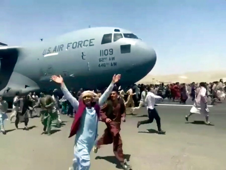 Hundreds of people run alongside a U.S. Air Force C-17 transport plane as it moves down a runway of the international airport, in Kabul, Afghanistan on Aug.16. 2021. Thousands of Afghans have rushed onto the tarmac of Kabul’s international airport, some so desperate to escape the Taliban capture of their country that they held onto an American military jet as it took off and plunged to death. (Verified UGC via AP)