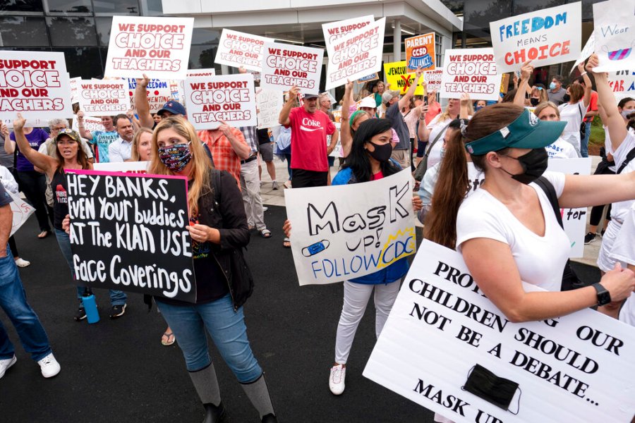 People in favor of and against a mask mandate for Cobb County schools gather and protest ahead of the school board meeting Thursday, Aug. 19, 2021, in Marietta, Ga. (Ben Gray/Atlanta Journal-Constitution via AP)