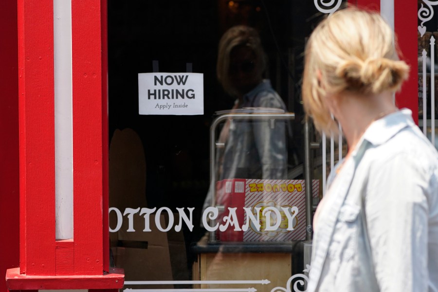 A "NOW HIRING" sign is posted in the window of The Wharf Chocolate Factory at Fisherman's Wharf in Monterey on Aug. 6, 2021. (Rich Pedroncelli / Associated Press)