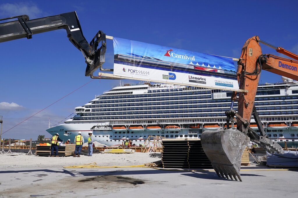 In this Friday, Jan. 29, 2021 photo, The Carnival Dream cruise ship arrives as construction work is underway for Carnival Cruise Line's new Terminal F, which will be the homeport to the Carnival Celebration cruise ship at PortMiami, in Miami. (AP Photo/Lynne Sladky)