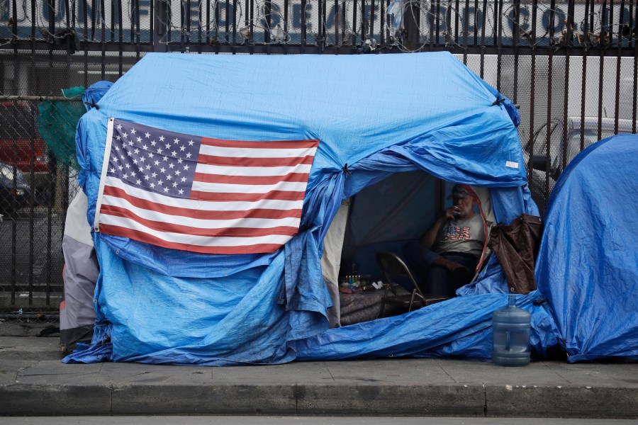 A man smokes inside a tent on skid row in Los Angeles on March 20, 2020. (Marcio Jose Sanchez / Associated Press)