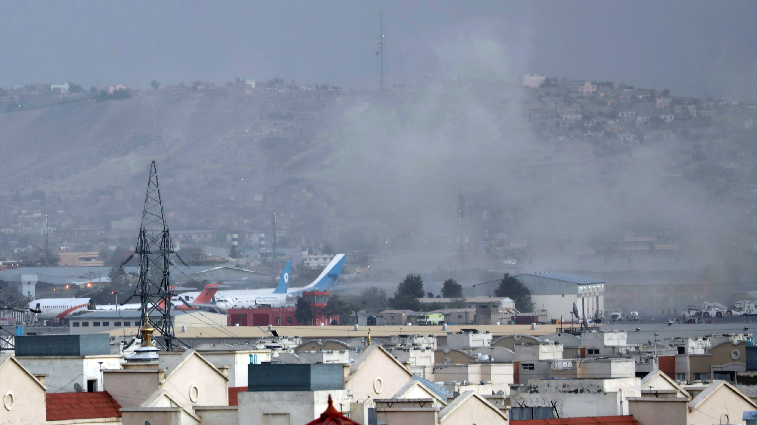 Smoke rises from a deadly explosion outside the airport in Kabul, Afghanistan, Thursday, Aug. 26, 2021. Two suicide bombers and gunmen have targeted crowds massing near the Kabul airport, in the waning days of a massive airlift that has drawn thousands of people seeking to flee the Taliban takeover of Afghanistan. (AP Photo/Wali Sabawoon)