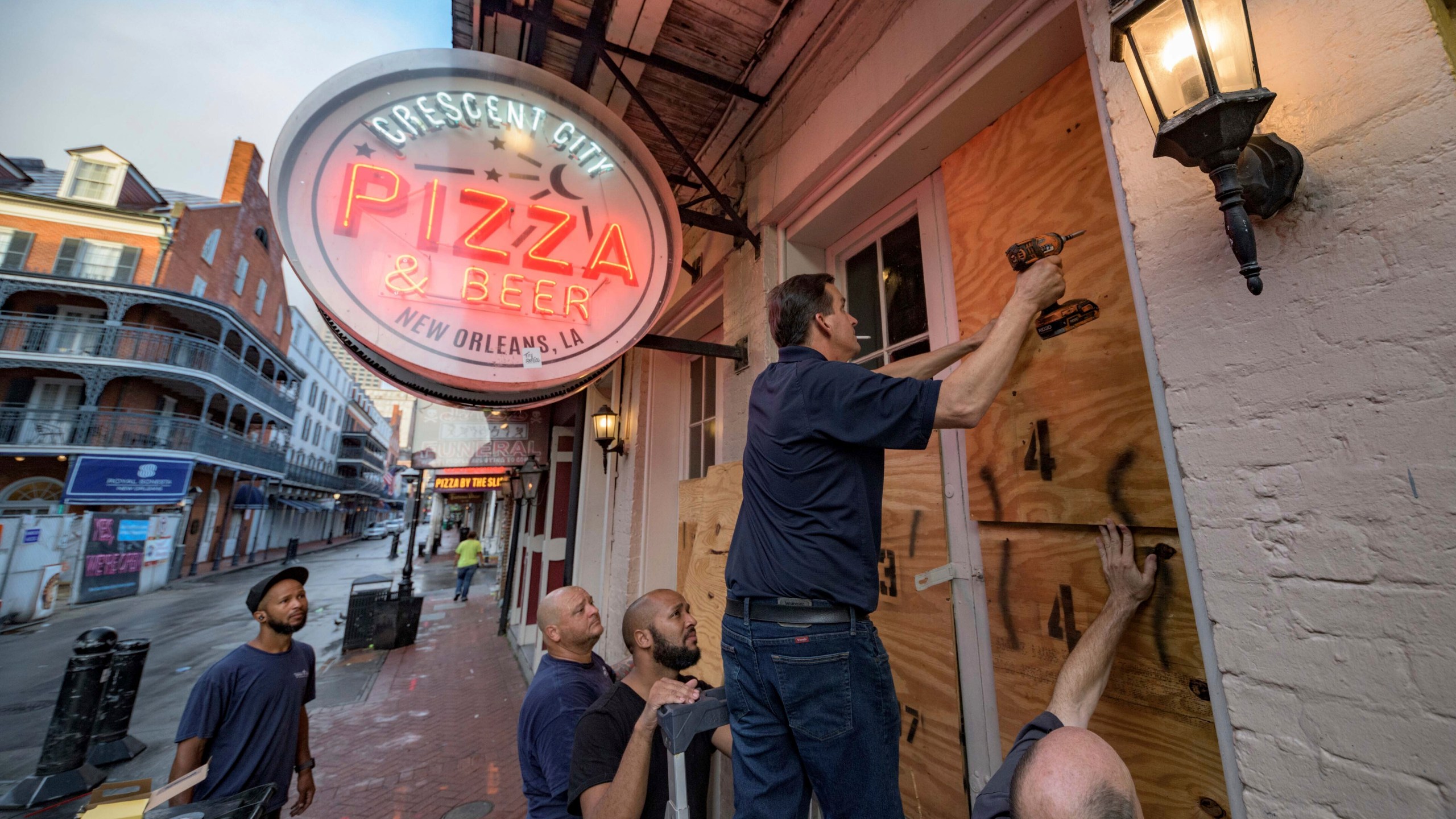 Michael Richard of Creole Cuisine Restaurant Concepts boards up Crescent City Pizza on Bourbon Street in the French Quarter before landfall of Hurricane Ida in New Orleans, Saturday, Aug. 28, 2021. Richard said the group is planning to board up and protect 34 restaurants owned by the company for the storm. (AP Photo/Matthew Hinton)