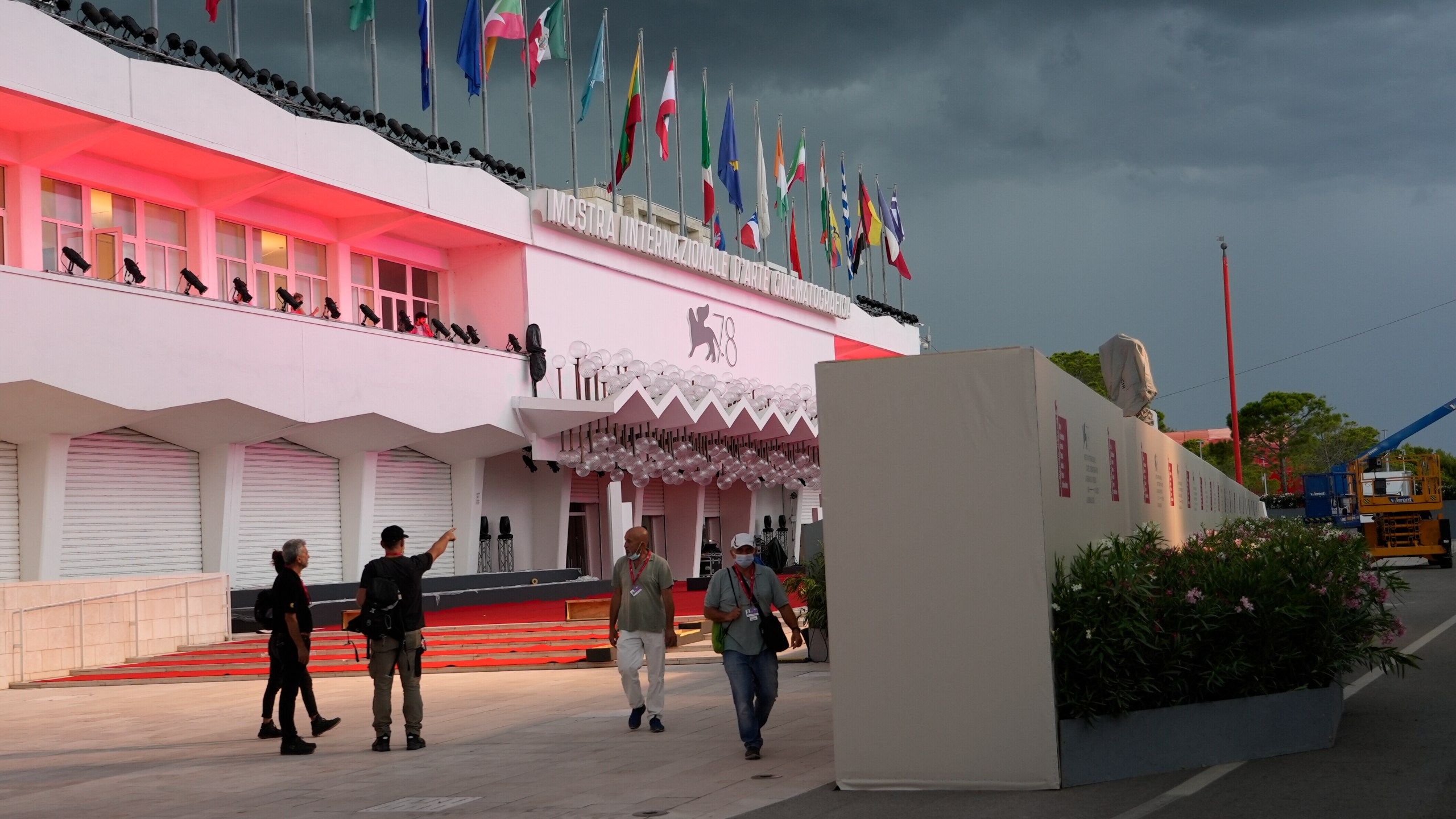 Workers walk by a wall hiding the red carpet of the 78th edition of the Venice Film Festival from the view of the public at the Venice Lido, Italy on Aug. 30, 2021. (Domenico Stinellis/Associated Press)