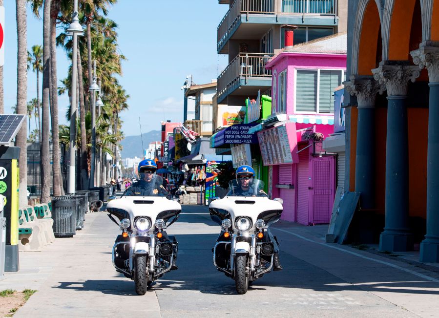 This file photo shows police officers patrolling the boardwalk in Venice Beach on May 13, 2020.(VALERIE MACON/AFP via Getty Images)