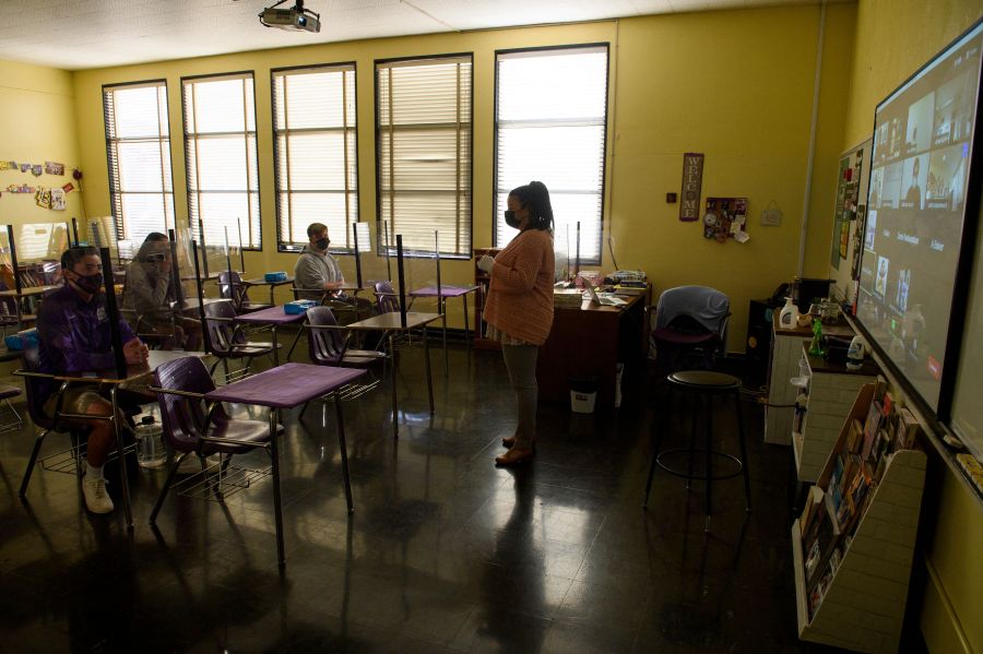 This undated file photo shows a teacher speaking with students in the classroom at a catholic high school in Long Beach on March 24, 2021. (PATRICK T. FALLON/AFP via Getty Images)