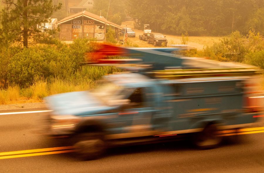 A PG&E truck passes by a home with a message to firefighters during the Dixie Fire near Quincy on July 26, 2021. (JOSH EDELSON/AFP via Getty Images)