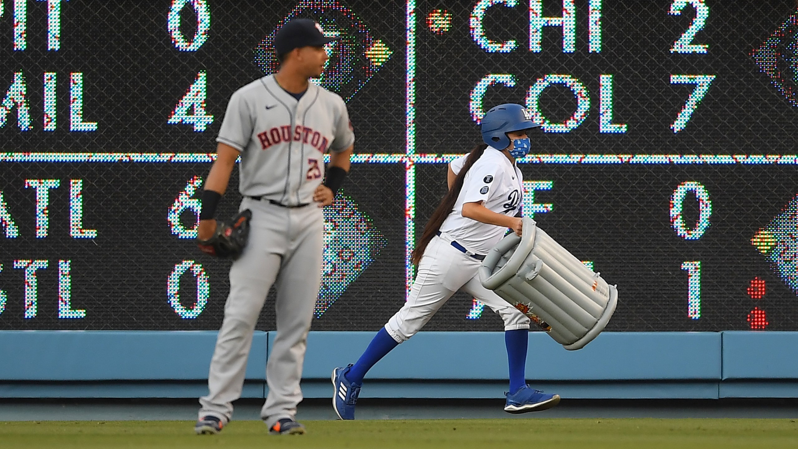 Michael Brantley #23 of the Houston Astros watches as a bat girl removes an inflatable trash can that was thrown onto the field in the first inning against the Los Angeles Dodgers at Dodger Stadium on Aug. 3, 2021, in Los Angeles, California. (Jayne Kamin-Oncea/Getty Images)