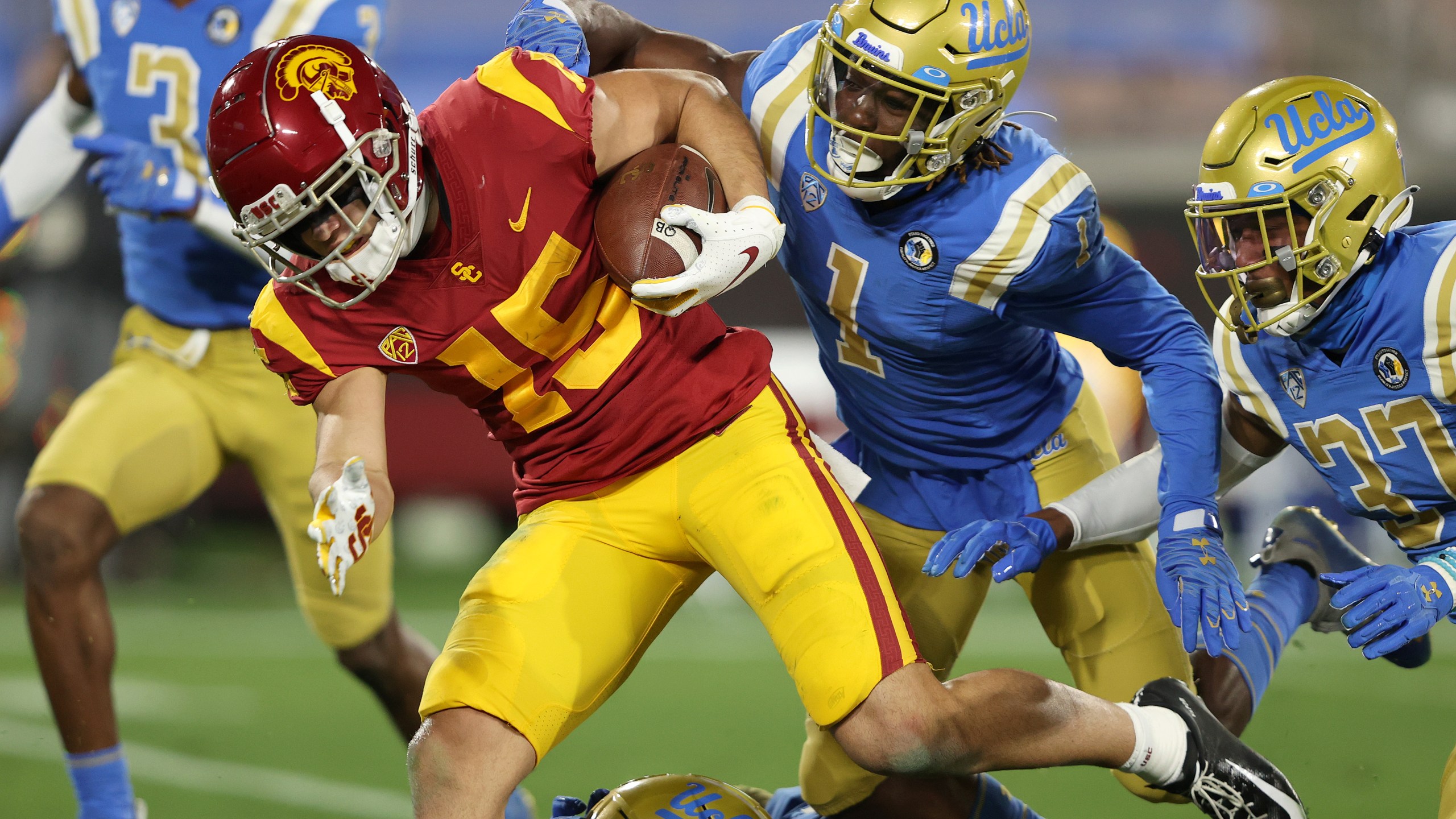 Drake London of the USC Trojans runs past Jay Shaw and Quentin Lake of the UCLA Bruins for a touchdown during the first half of a game at the Rose Bowl on Dec. 12, 2020 in Pasadena, California. (Sean M. Haffey/Getty Images)