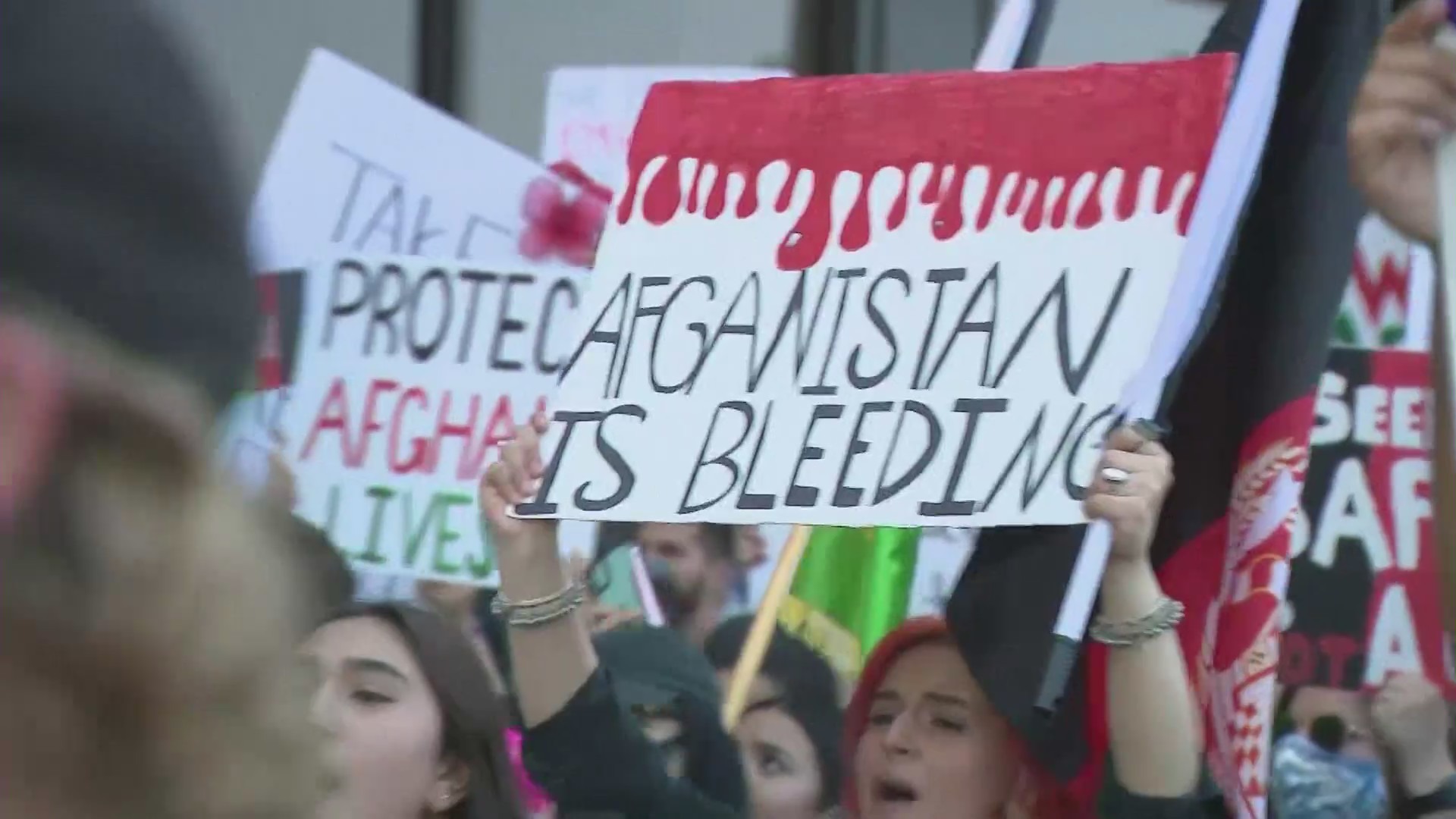 A woman holds up a sign during a rally to show support for the people of Afghanistan on Saturday, Aug. 28, 2021 in Westwood.