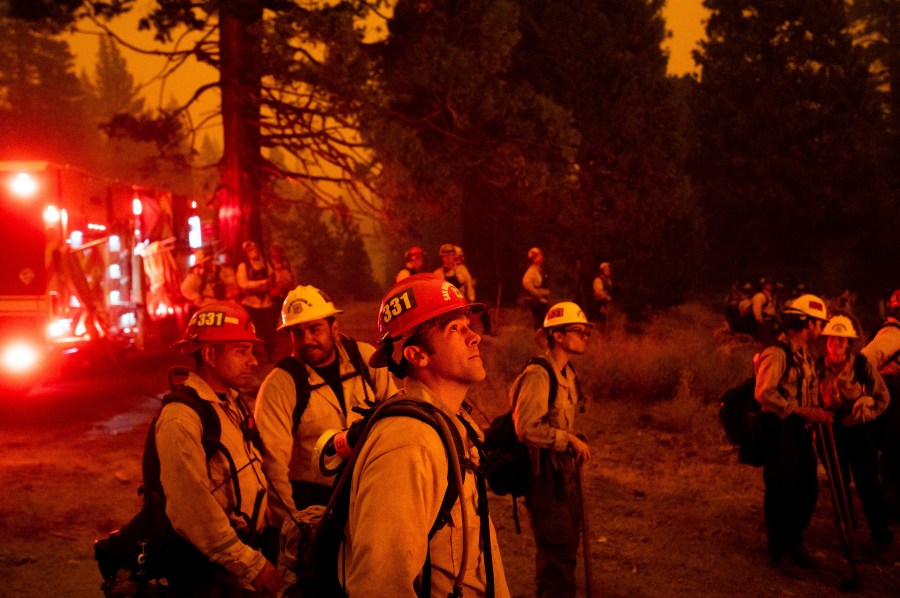 In this Thursday, Aug. 26, 2021 file photo, Capt. Adam Tinker and his crew monitor a firing operation, where crews burn vegetation to create a control line, while battling the Caldor Fire in Eldorado National Forest. (AP Photo/Noah Berger, File)