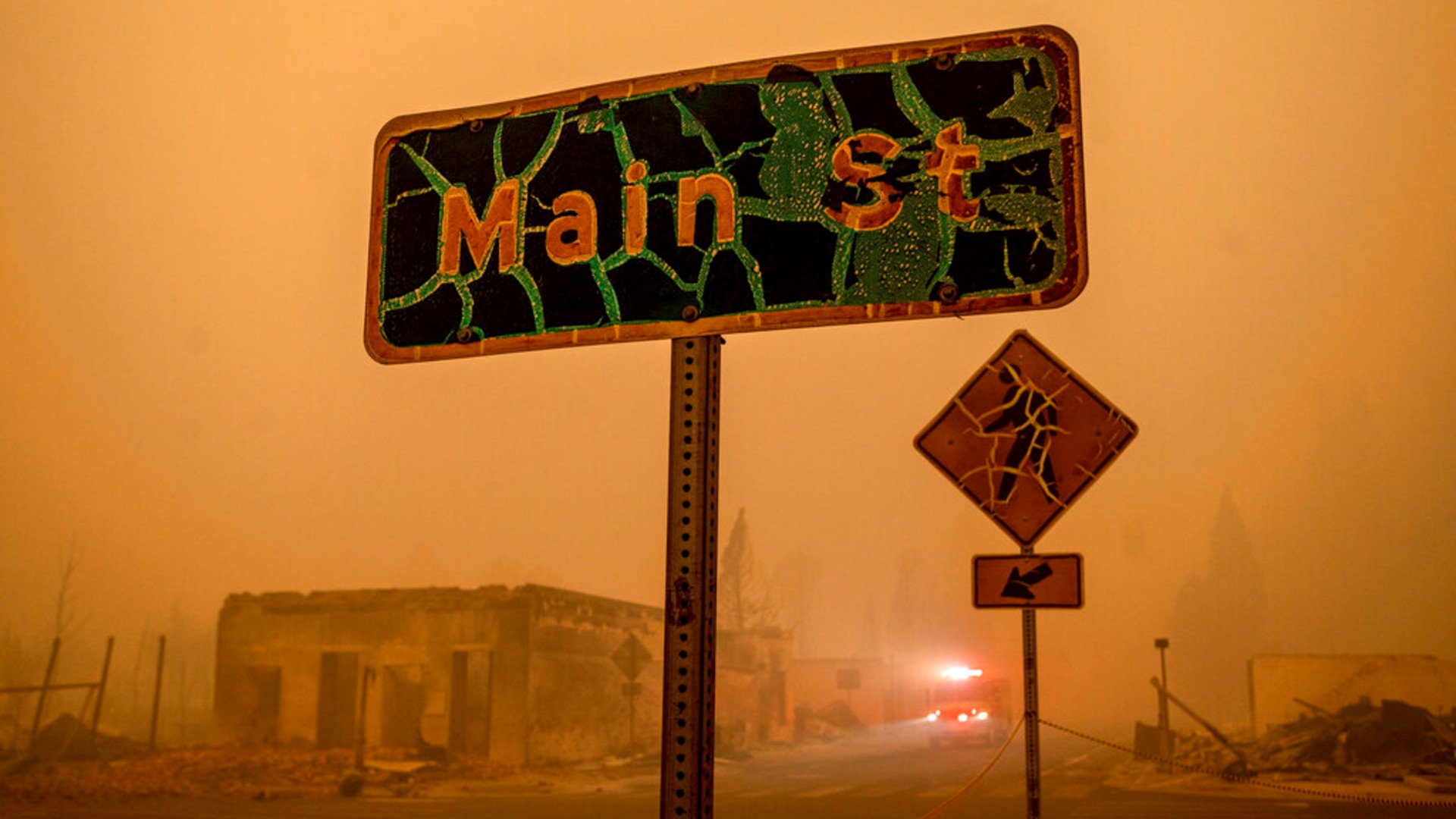 A fire truck drives through central Greenville, which was largely leveled by the Dixie Fire, Friday, Aug. 6, 2021, in Plumas County, Calif. (AP Photo/Noah Berger)