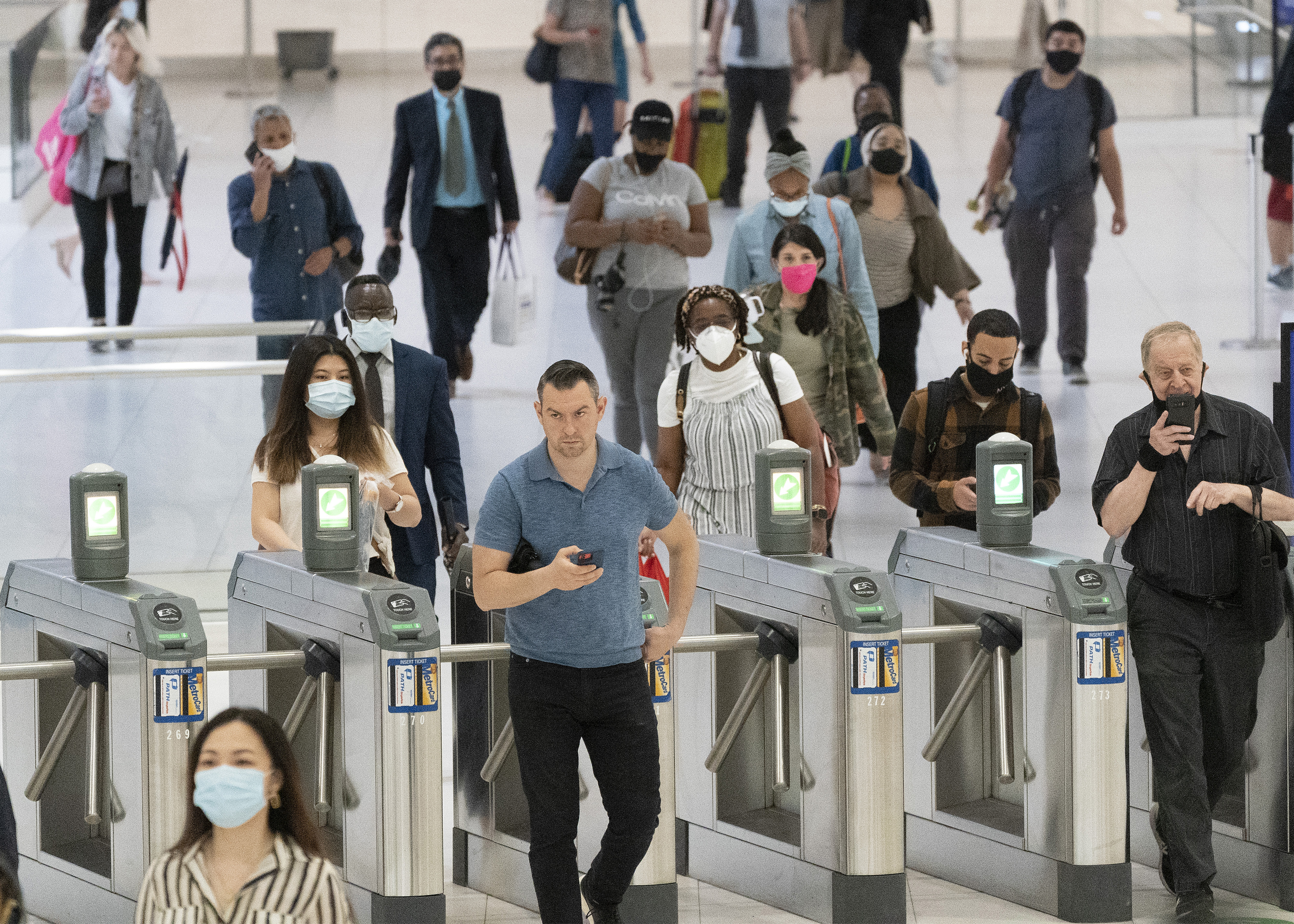 People commute through the World Trade Center, Friday, July 9, 2021, in New York. Businesses that have announced vaccine mandates say some workers who had been on the fence have since gotten inoculated against COVID-19. But many holdouts remain, a likely sign of what is to come once a federal mandate goes into effect. (AP Photo/Mark Lennihan)