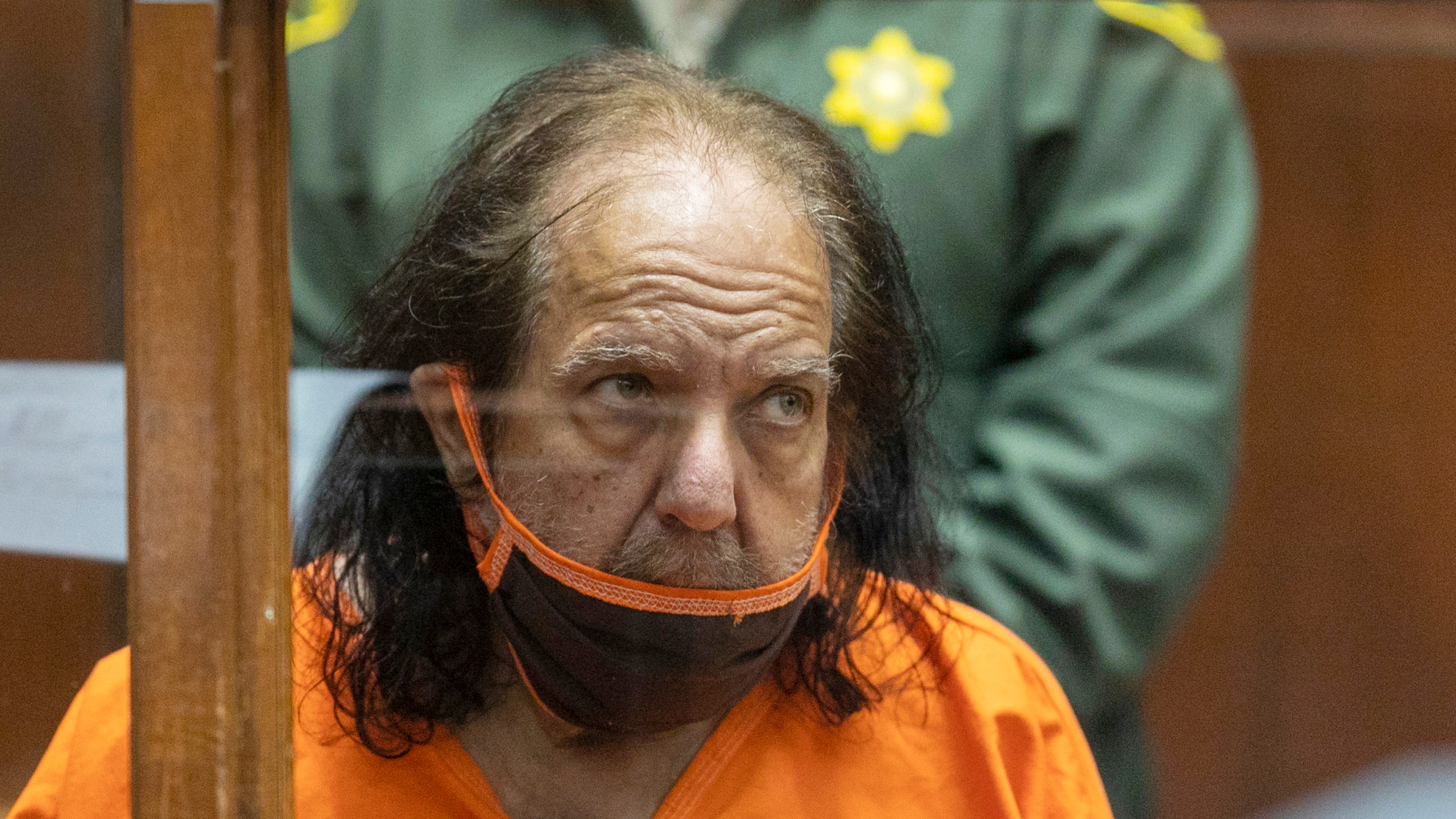 In this June 26, 2020, file photo, adult film performer Ron Jeremy appears for his arraignment on rape and sexual assault charges at Clara Shortridge Foltz Criminal Justice Center in Los Angeles. A grand jury has indicted adult film actor Ron Jeremy on more than 30 counts of sexual assault involving 21 women and girls across more than two decades, authorities said. Jeremy, 68, whose legal name is Ronald Jeremy Hyatt, pleaded not guilty in Los Angeles Superior Court on Wednesday, Aug. 25, 2021, to all of the allegations, which include 12 counts of rape. (AP Photo/David McNew, Pool, File)