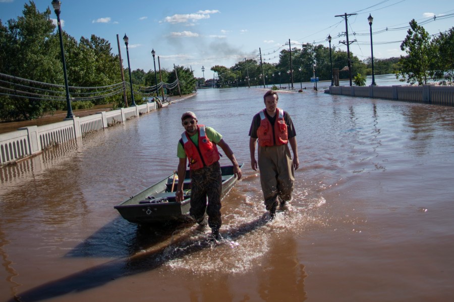 United States Geological Survey workers push a boat as they look for residents on a street flooded as a result of the remnants of Hurricane Ida in Somerville, NJ., Thursday, Sept. 2, 2021. (AP Photo/Eduardo Munoz Alvarez)