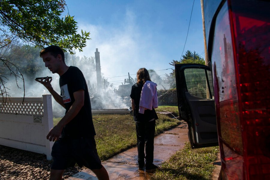 Jason Marotta, right, speaks on his phone as his brother watches the remains of their house that was destroyed due to severe flooding from Tropical Storm Ida in Manville, NJ., Friday, Sept. 3, 2021. (AP Photo/Eduardo Munoz Alvarez)