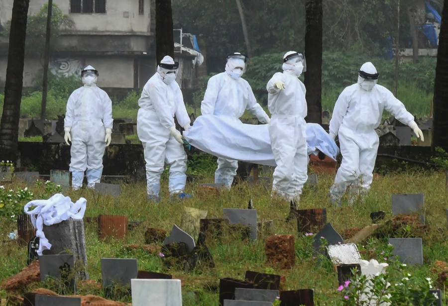 People in protective suits prepare to cremate the body of a 12-year-old boy died of the Nipah virus in Kozhikode, Kerala state, India, Sunday, Sept.5, 2021. The southern Indian state is quickly ramping up efforts to stop a potential outbreak of the deadly Nipah virus, even as it continues to battle the highest number of coronavirus cases in the country. (AP Photo/Shijith. K)