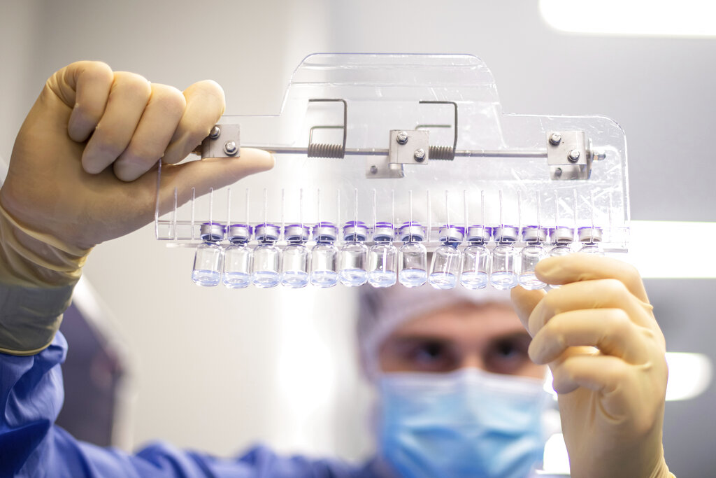 In this March 2021 photo provided by Pfizer, a technician inspects filled vials of the Pfizer-BioNTech COVID-19 vaccine at the company's facility in Puurs, Belgium. (Pfizer via AP)