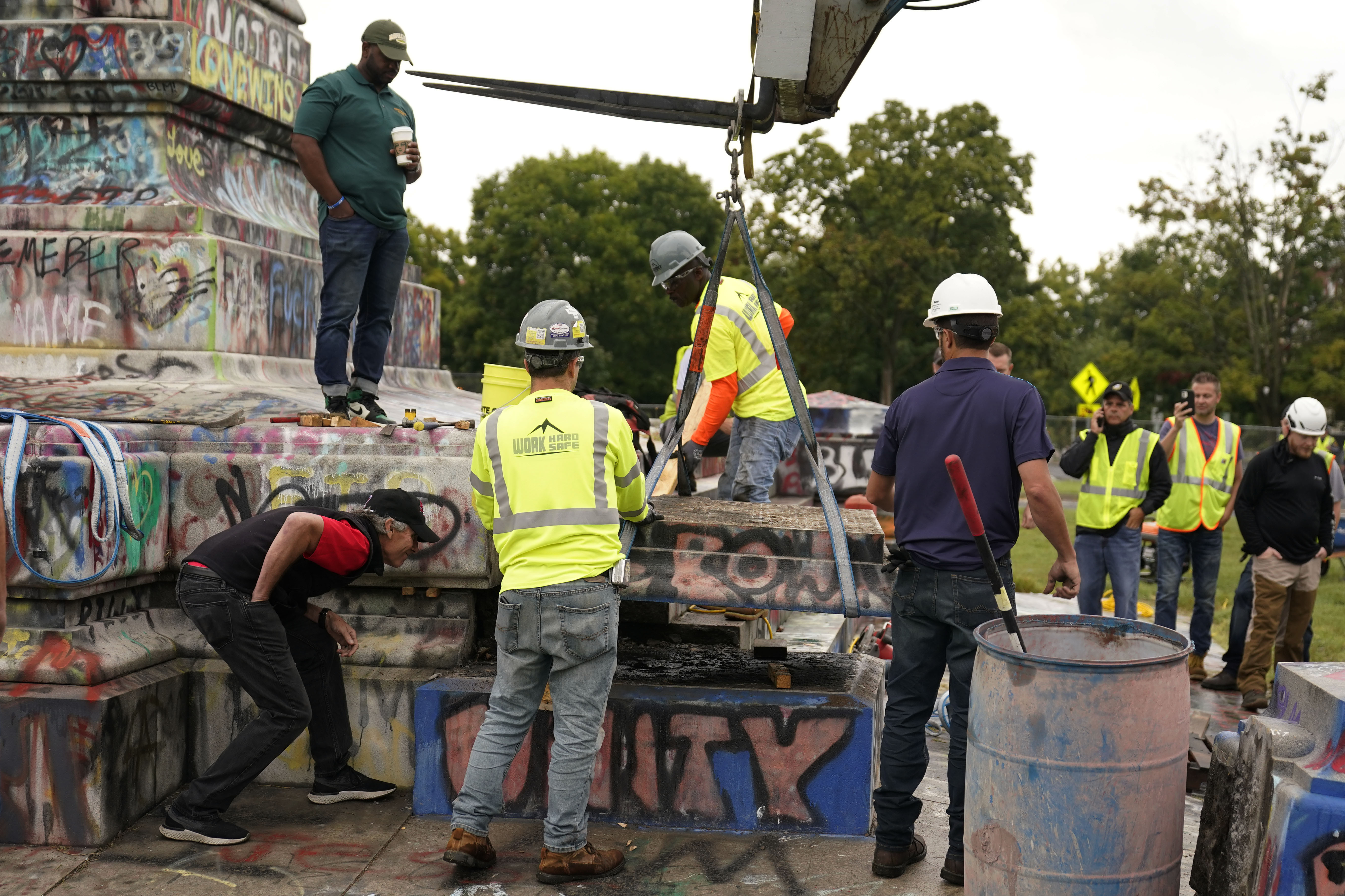 Crews move a section of the base as they attempt to locate a time capsule said to be buried in the base of the statue of on Monument Avenue in Richmond, Va., Thursday, Sept. 9, 2021. The statue was removed from the pedestal on Wednesday. (AP Photo/Steve Helber)