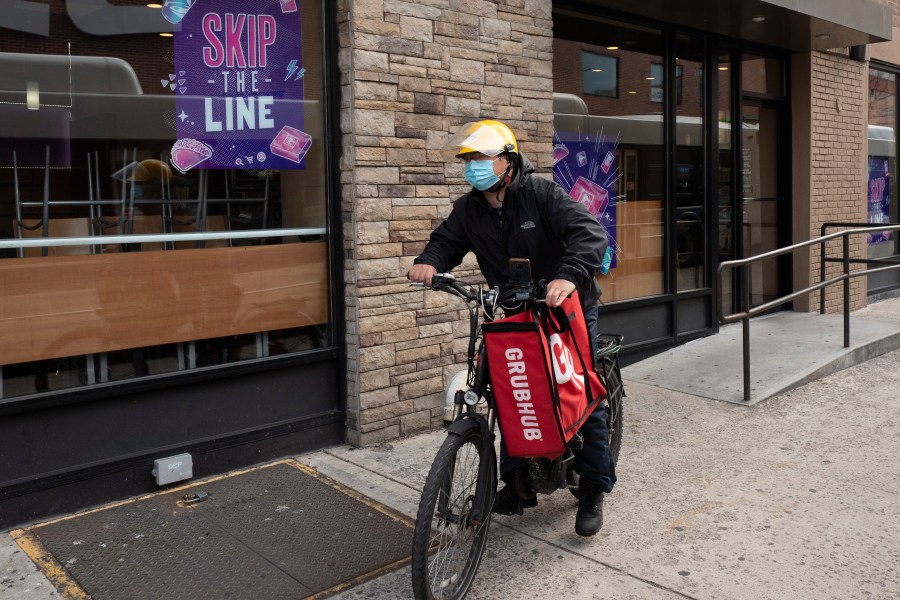 In this April 21, 2021, file photo, a delivery man bikes with a food bag from Grubhub in New York. (AP Photo/Mark Lennihan, File)