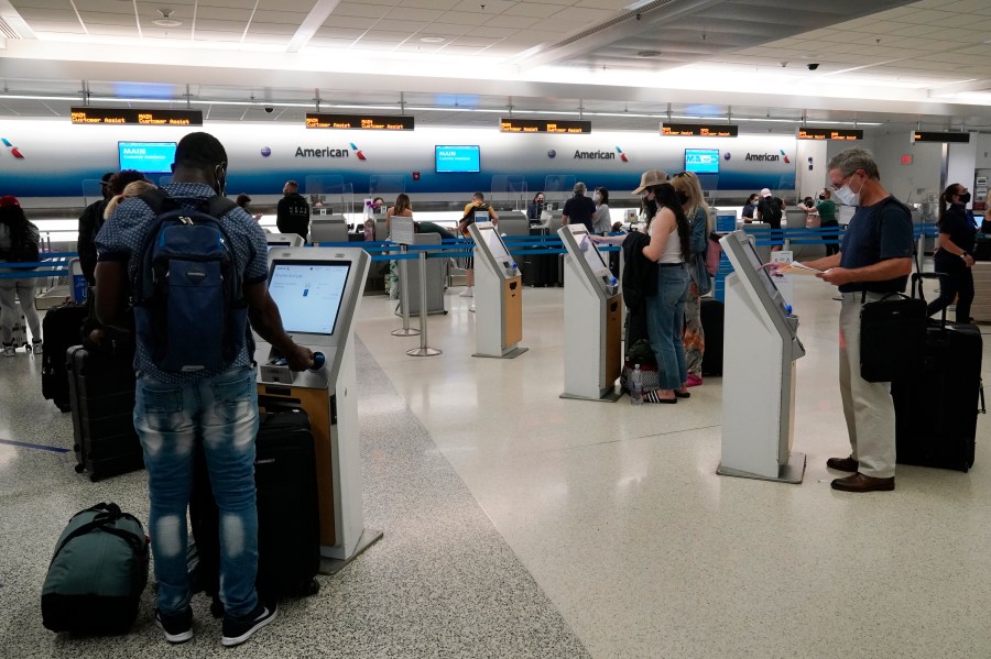 In this April 29, 2021 photo, travelers use the self-service kiosk to check in and pay for luggage at the American Airlines terminal in Miami. The Transportation Department is detailing efforts it's making to help airline customers who didn't get refunds after their flights were canceled during the early days of the pandemic last year. The department says, Friday, Sept. 10, in a new report that it investigated 20 airlines over failures to issue prompt refunds to customers, and 18 of those probes are still going on.(AP Photo/Marta Lavandier)