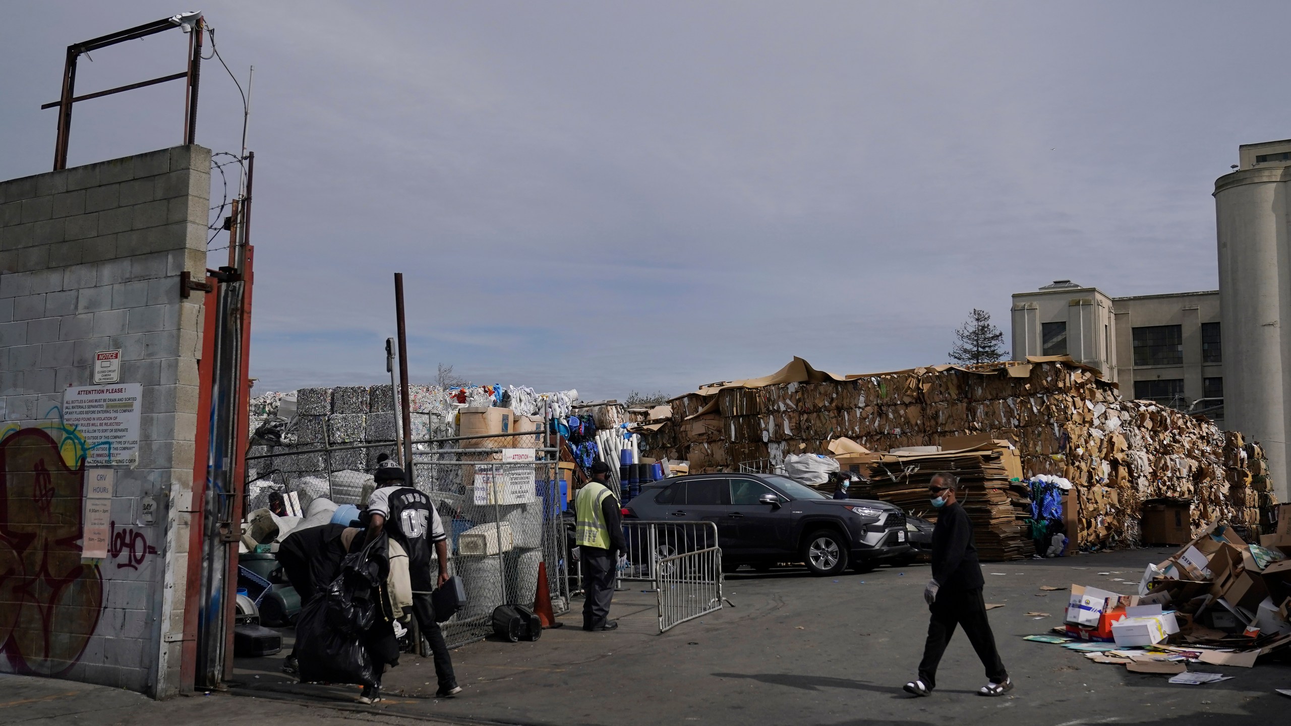 In this Feb. 18, 2021, file photo, people walk inside a recycling location in Oakland, Calif. California lawmakers have approved what advocacy groups say are the nation's strongest protections against falsely labeling items as recyclable when they in fact are destined for landfills. (AP Photo/Jeff Chiu, File)