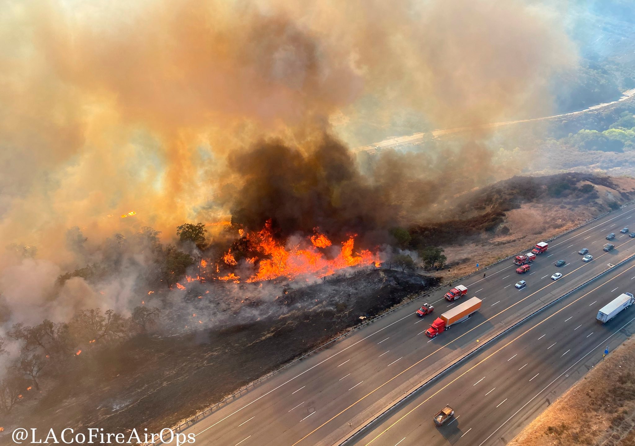 In this aerial photo released by the Los Angeles County Fire Department Air Operations traffic passes the Route fire, a brush wildfire off Interstate 5 north of Castaic, Calif., on Saturday, Sept. 11, 2021. (Los Angeles County Fire Air Operations via AP)