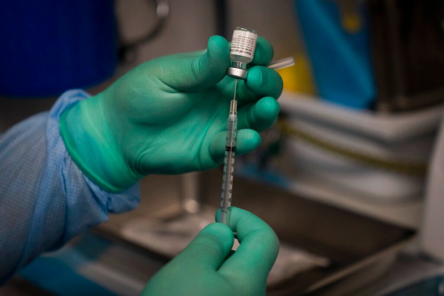 In this Aug. 26, 2021 file photo, Parsia Jahanbani prepares a syringe with the Pfizer COVID-19 vaccine in a mobile vaccine clinic operated by Families Together of Orange County in Santa Ana, California. (AP Photo/Jae C. Hong, File)