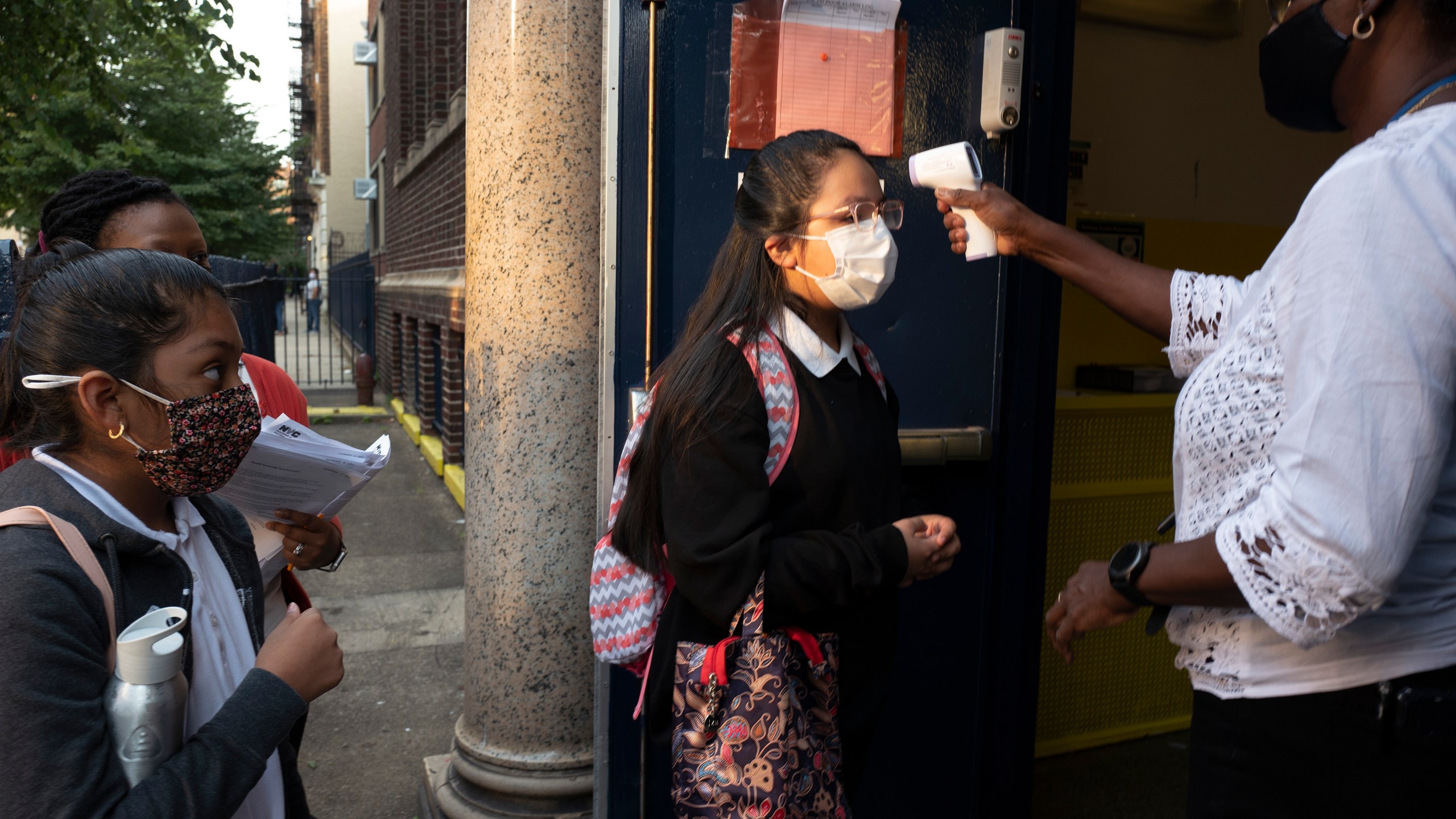 A girl has her temperature checked as she arrives for the first day of school at Brooklyn's PS 245 elementary school on Sept. 13, 2021, in New York. (Mark Lennihan/Associated Press)